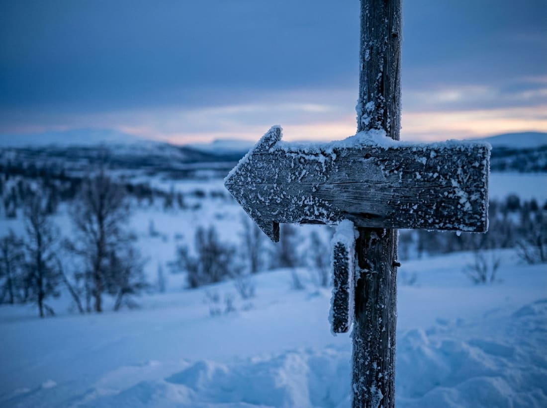 Panneau indicateur sur la ligne du cercle polaire arctique, dans un paysage enneigé de Laponie