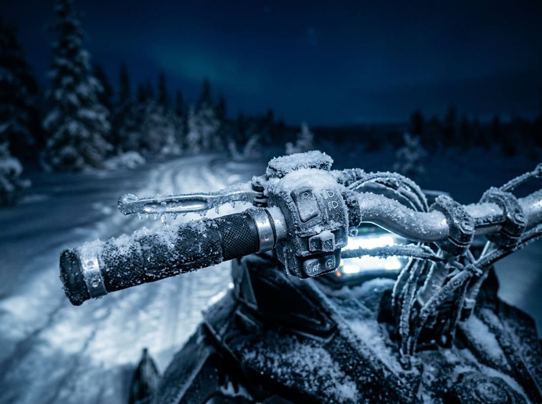 Guidon givré d'une motoneige sur une piste enneigée de Laponie à la tombée de la nuit
